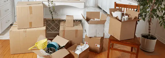 Packed moving boxes and household items in a kitchen before move-out or move-in cleaning, Anchorage, AK.